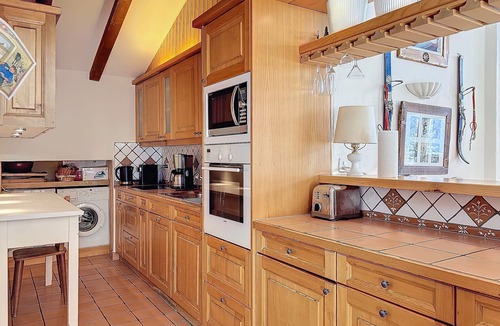 Verbier Apartment | An entrance with a guest toilet, a spacious living room with fireplace and TV corner, an open kitche