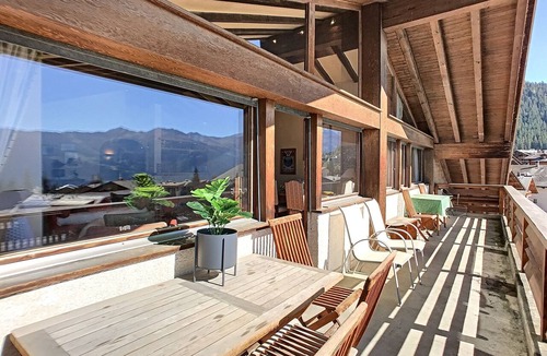 Verbier Apartment | An entrance with a guest toilet, a spacious living room with fireplace and TV corner, an open kitche