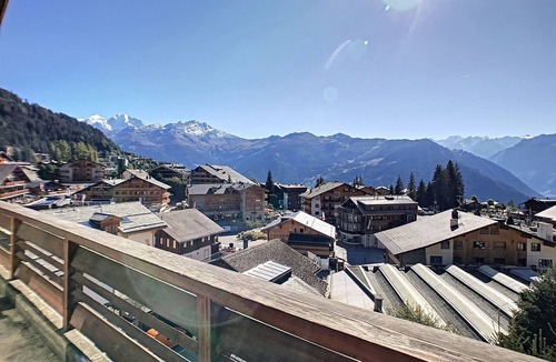 Verbier Apartment | An entrance with a guest toilet, a spacious living room with fireplace and TV corner, an open kitche