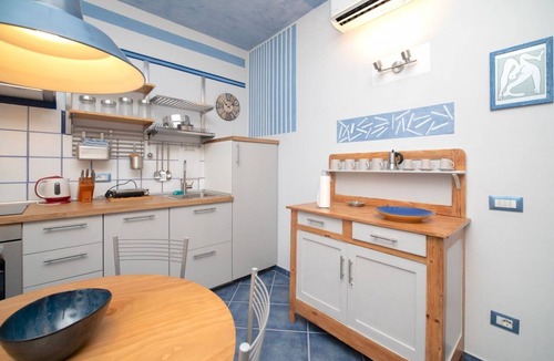 Arona Apartment | Charming one-bedroom apartment, finely furnished, located on the ground floor of Via Pertossi in the historic centre of Arona.Casa Azzurra is a 52 sqm one-bedroom apartment with air conditioning, featuring a living room/kitchen area with a double sofa be